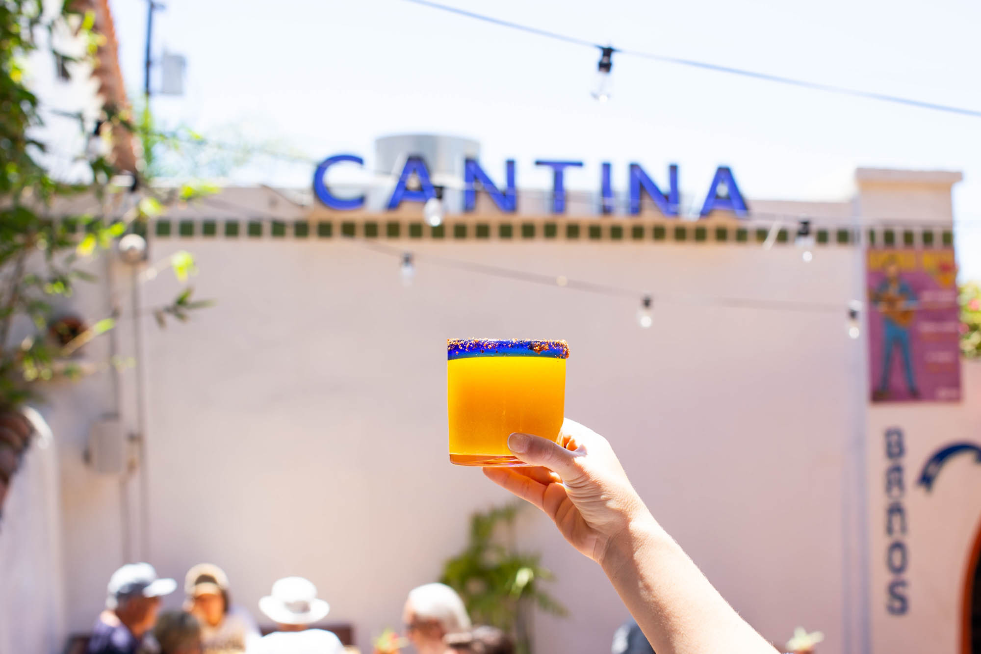 It is a mango margarita held in the air with our CANTINA sign in the background