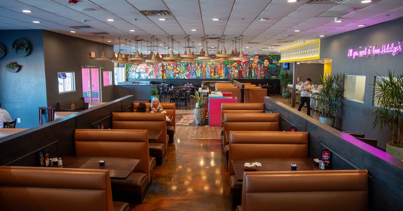 Interior, dining area, seating booths with tables left and right, room dividers