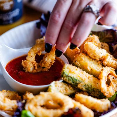 A hand dipping food.