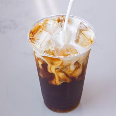 Iced latte served in a plastic cup with a straw.