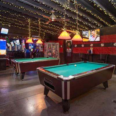 Interior featuring two pool tables and string lights hanging from the ceiling.
