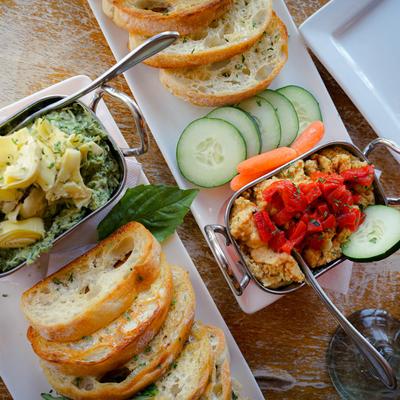 Spinach and artichoke dip and hummus dip served with crostini, overhead view