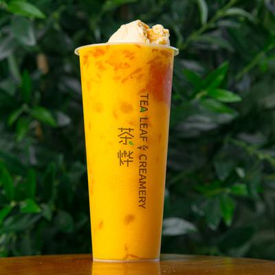 Mango Pomelo Sago tea with ice cream set against a leafy green background.