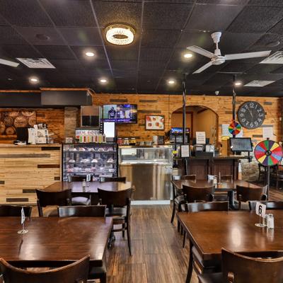 Interior with tables, chairs and counter area with a refrigerated display case.