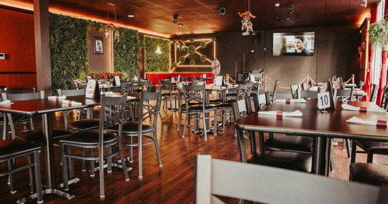 Interior, open space dining area, tables for four and six, TV on the wall