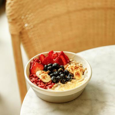 Fruit yogurt bowl with strawberries, blueberries, bananas, granola.