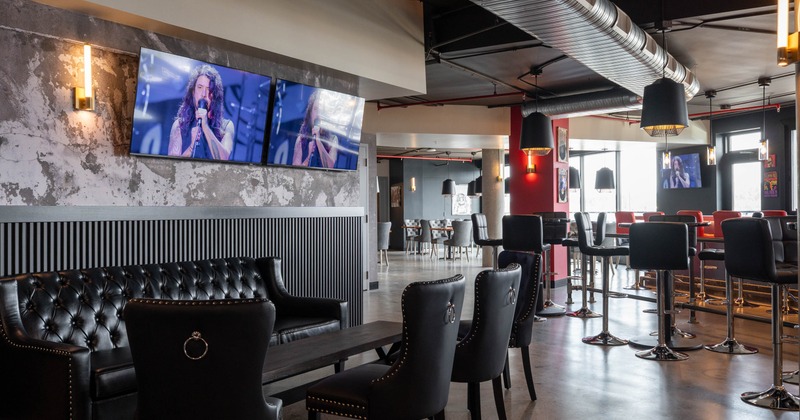 Interior, leather sofa with chairs and TVs on the wall