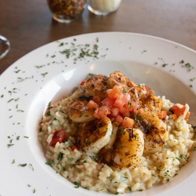 Shrimp Risotto topped with diced tomato and herbs.