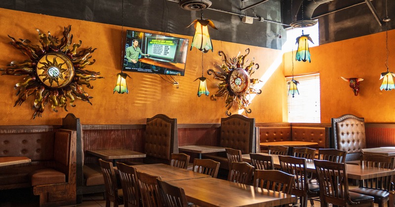Interior, dining area, tables with chairs, padded seating booths with tables, lanterns