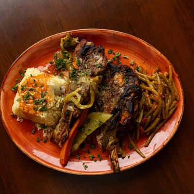 Baked lamb, with peppers, olive oil, oregano sauce, rice, and green beans.