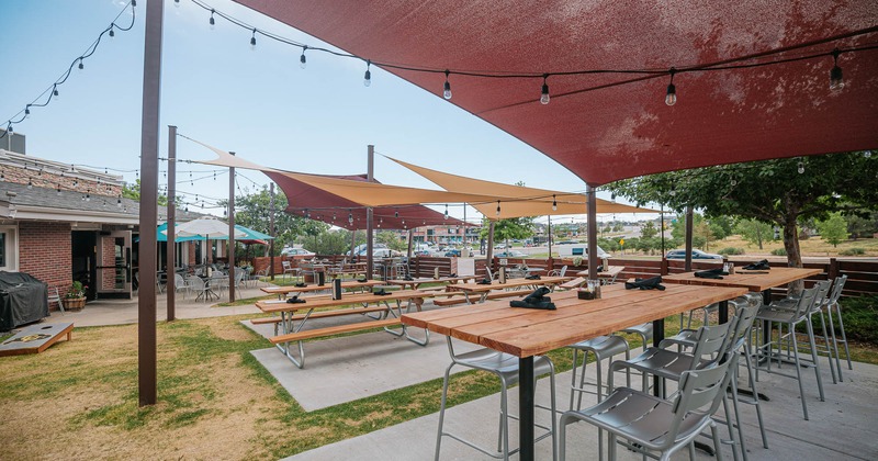 Patio, tables and seating with parasols and shade sails