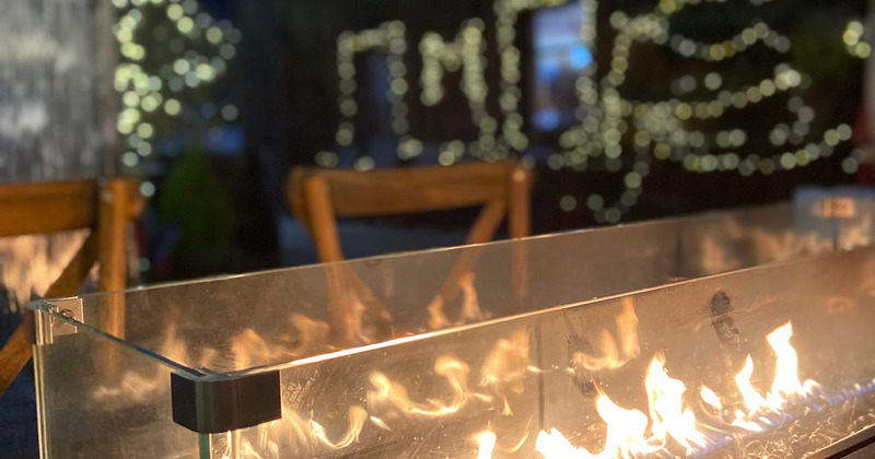 Patio, fire pit with glass wind screen on a table