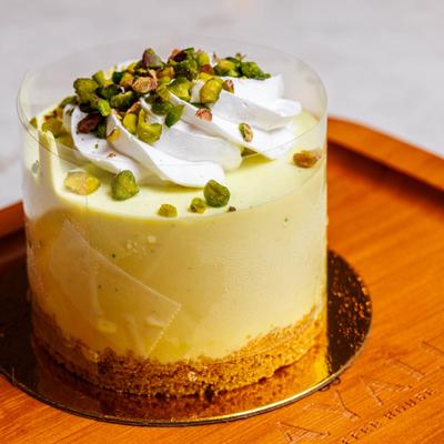 Pistachio Cheesecake served on a wooden plate.