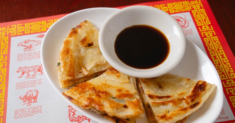 Slices of Chinese pizza with a cup of soy sauce