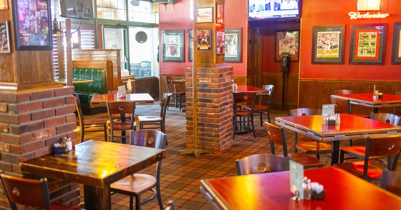 Interior, dining area, wooden top tables for four and two, red brick and wood pillars
