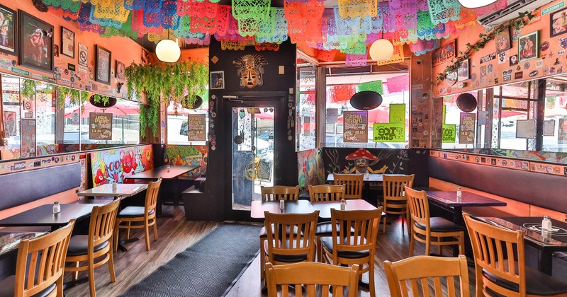 Colorful interior with picado banners, artwork, wooden tables and chairs, entrance
