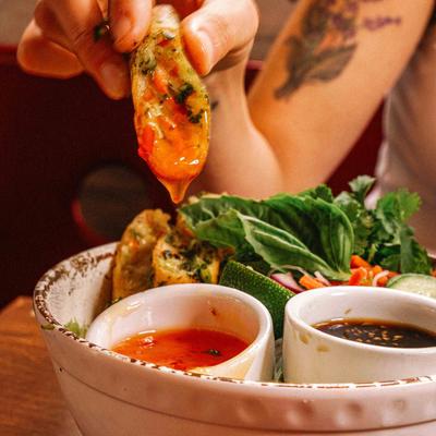Person dipping a stuffed bite into red sauce.