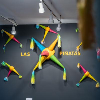 Colorful Mexican pinatas displayed on a wall with a Las Pinatas sign.