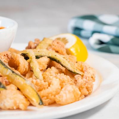 Fried calamari and deep-fried zucchini garnished with lemon.