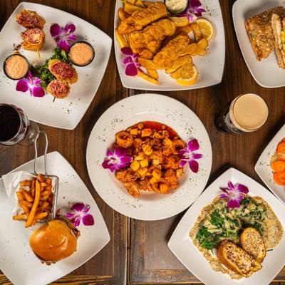 Assortment of food dishes, a glass of wine, and a glass of beer, top view