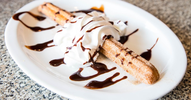 Churros with whipped cream and chocolate glaze