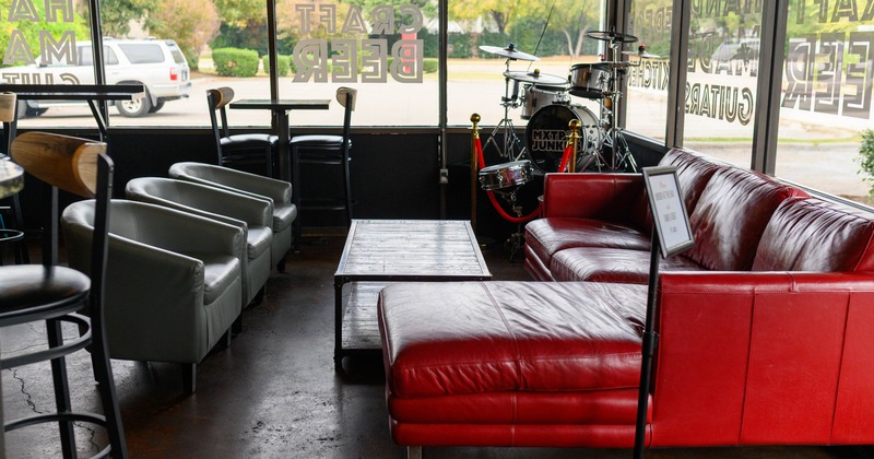 Leather seating set next to large windows and a small stage for musicians