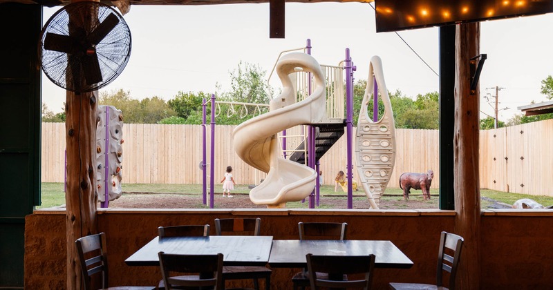 Interior, tables  and seating, view of the playground with children playing