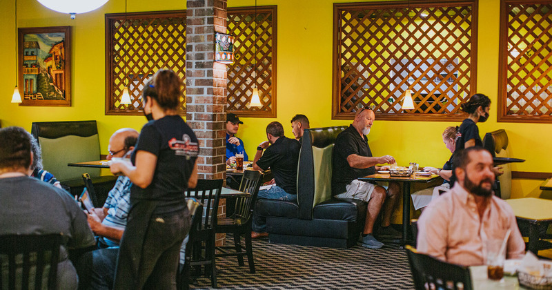 Restaurant dining area with booths, tables, and seated customers
