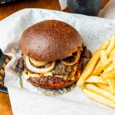 Korean BBQ Burger topped with grilled onions and served with fries.