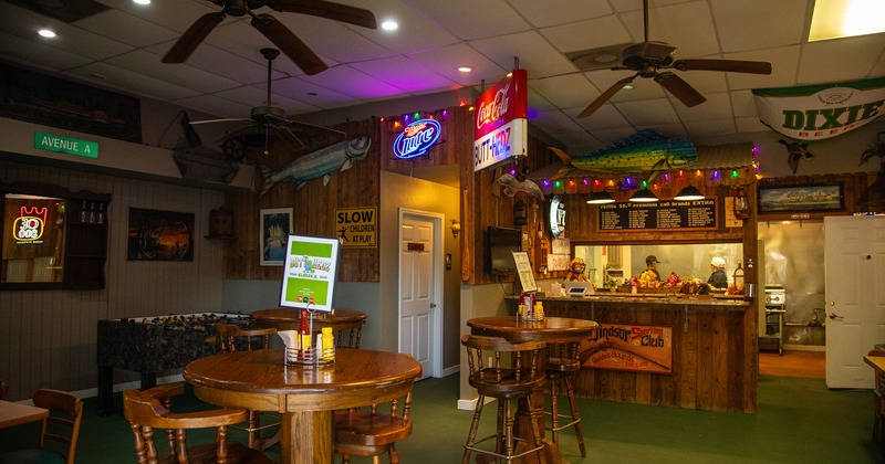 Cozy interior seating area with wooden round high tables and stools and an order counter