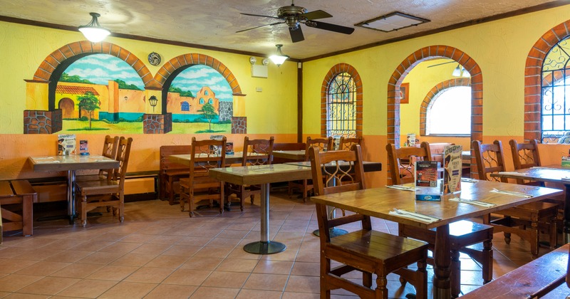 Interior, dining space with bright yellow walls with painted scenes