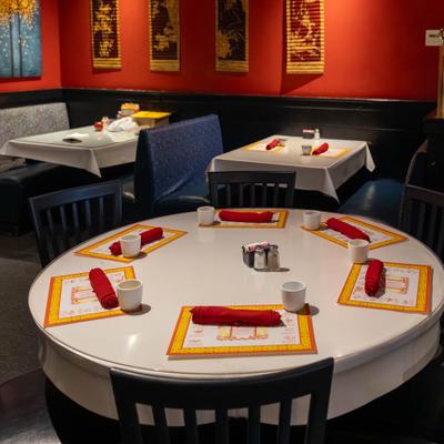 Round table with place settings and red napkins.