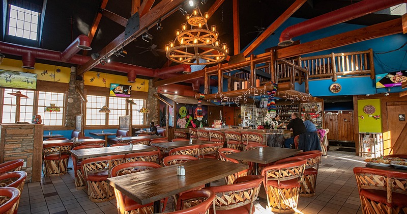 Interior, wide view, tables and chairs, bar on the right