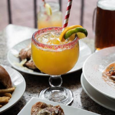 Margarita cocktail on a table with multiple food plates.