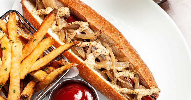Philly cheesesteak with seasoned fries and dip, top view