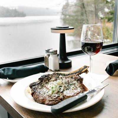 Grilled Cowboy Steak  served with a glass of red wine.