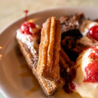 Caramel Filled Churros served on a plate with ice cream dessert.