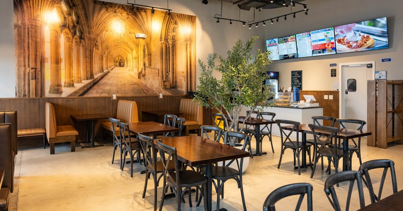 Interior - dark wood furniture, a large mural of an arched corridor, a potted tree.