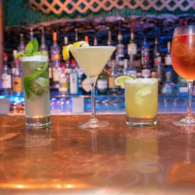 Assorted cocktails displayed on bar counter.