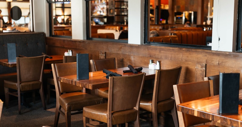 Restaurant interior with wooden tables and brown leather chairs