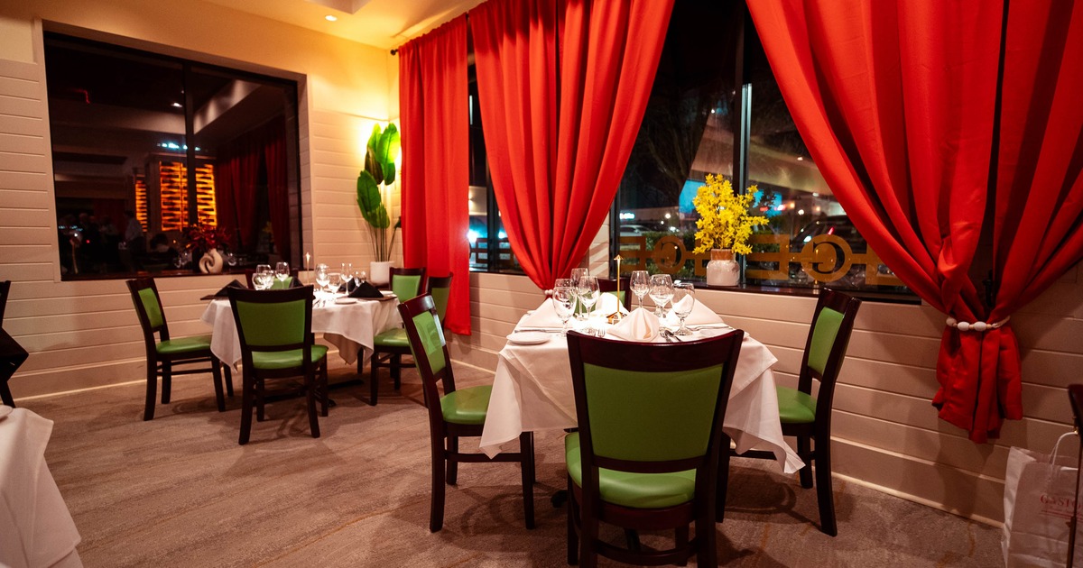Interior, dining area, white cloth tables for four, ready for guests, windows with red curtains
