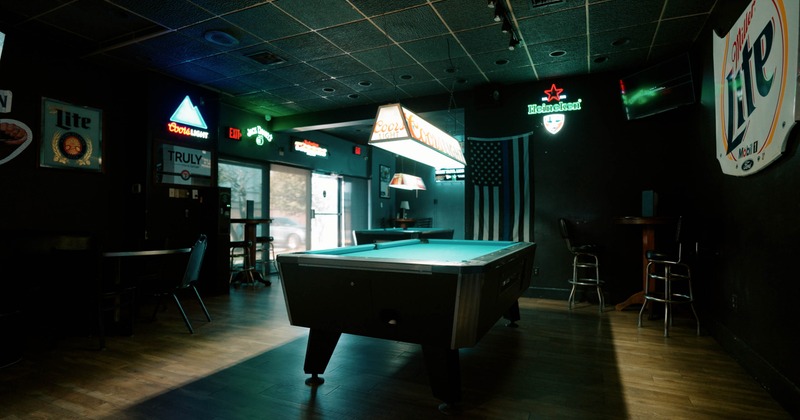 Pool table in a bar with beer signs