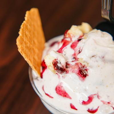 Strawberry vanilla ice cream served in a small bowl with a wafer cookie.