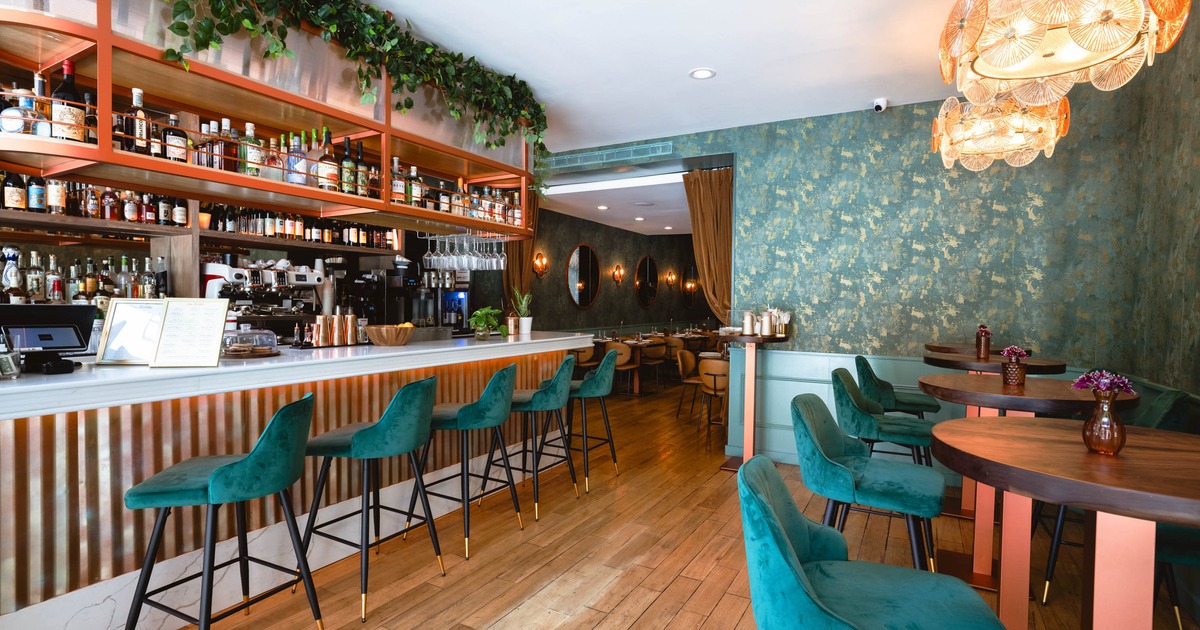Interior, contemporary design, marble bar, teal velvet chairs, and warm lighting
