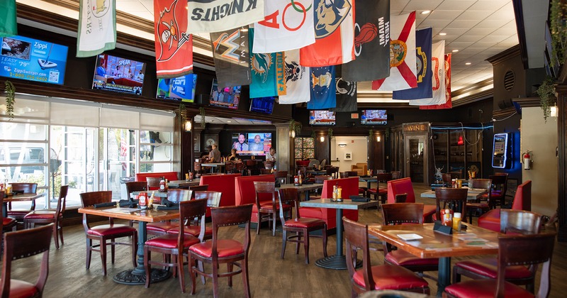 Interior space, dining tables, TV sets, flags hang from the ceiling