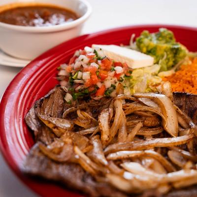 Flat steak with grilled onions,rice, guacamole, pico de gallo, and charro beans.