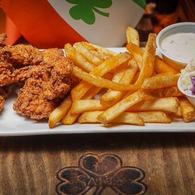Chicken tenders, coleslaw, dipping sauce, and fries.