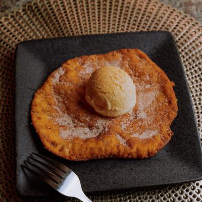 Sopapilla topped with cinnamon sugar and vanilla ice cream.