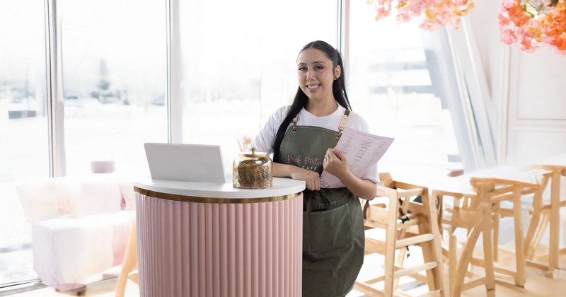 A smiling host standing at a front desk
