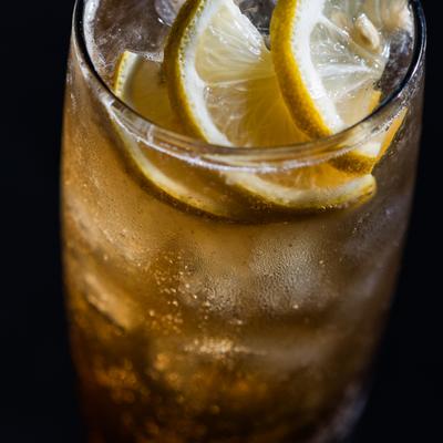 Iced drink garnished with lemon slices, close-up.